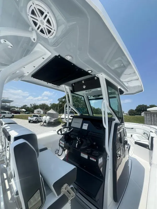 Slide: The Image of 2025 Blackfin 272 CC boat interior with modern console and seating under a clear sky. - 15