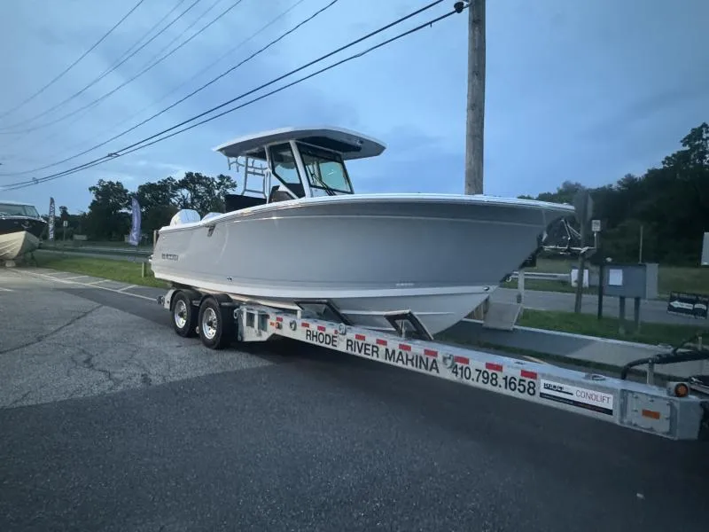 Slide: The Image of 2025 Blackfin 272 CC boat on trailer at dusk, parked near road. - 5