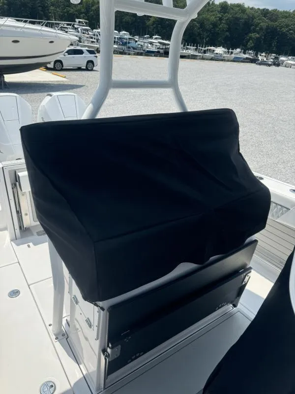 Slide: The Image of 2025 Blackfin 272 CC boat with covered console, docked in a marina. - 7