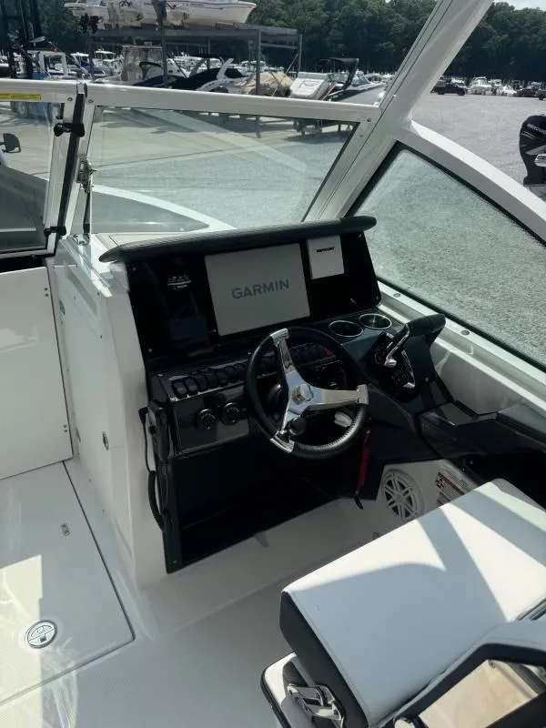 Slide: The Image of 2025 Blackfin 252 DC boat cockpit with Garmin navigation system and modern steering wheel. - 16