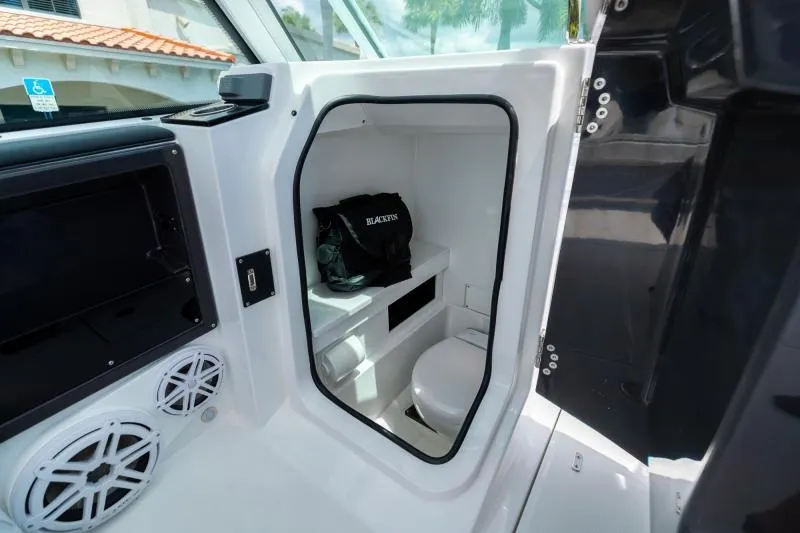 Slide: The Image of 2025 Blackfin 252 DC boat interior with compact restroom and storage area. - 17