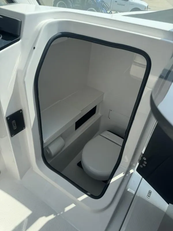 Slide: The Image of 2025 Blackfin 252 DC boat interior with compact marine toilet and storage. - 18