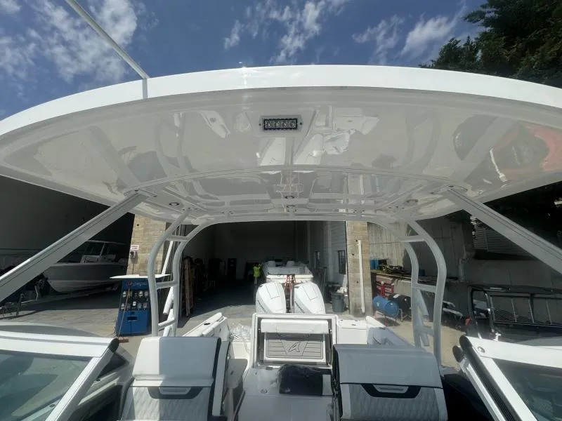 Slide: The Image of 2025 Blackfin 252 DC boat interior with hardtop, docked under a clear sky. - 20
