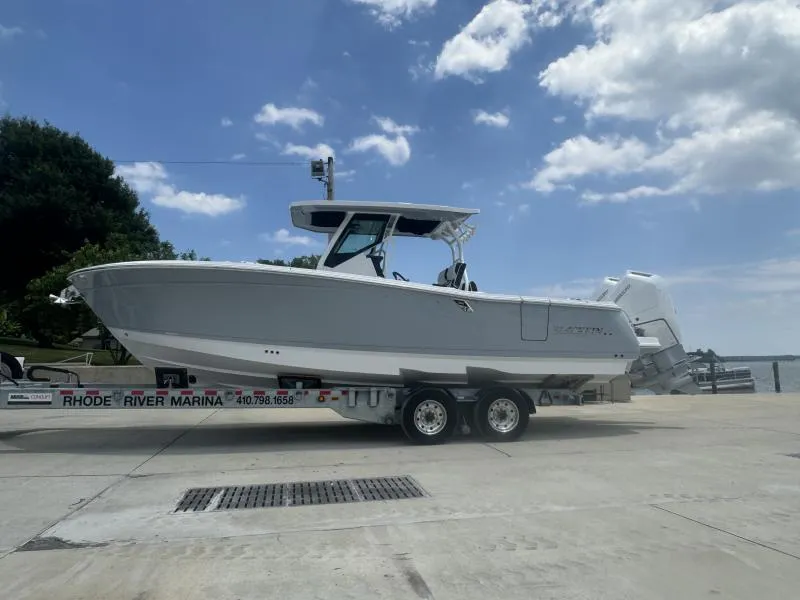 Slide: The Image of 2025 Blackfin 302 CC boat on trailer at Rhode River Marina under blue sky. - 2