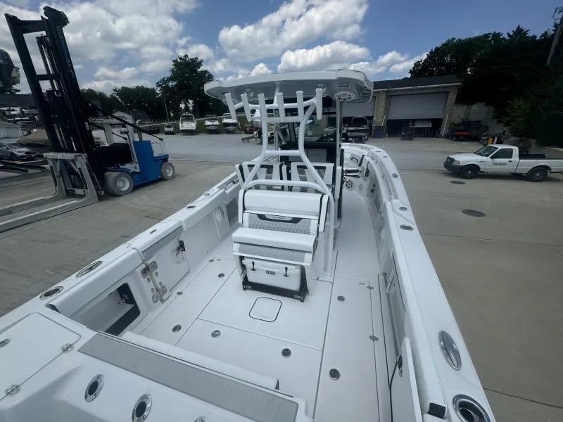 Slide: The Image of 2025 Blackfin 302 CC boat, spacious deck, docked at marina under cloudy sky. - 8
