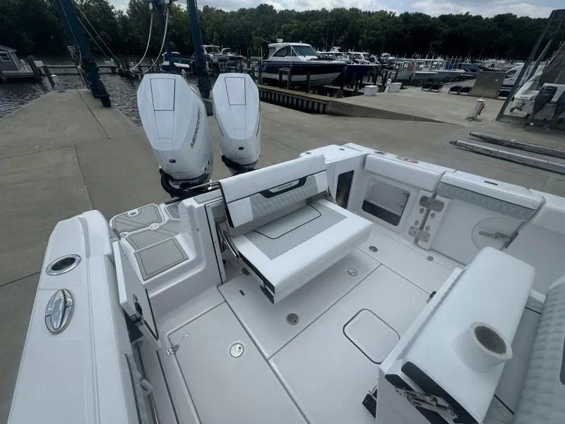 Slide: The Image of 2025 Blackfin 302 CC boat with dual engines at a marina dock. - 9