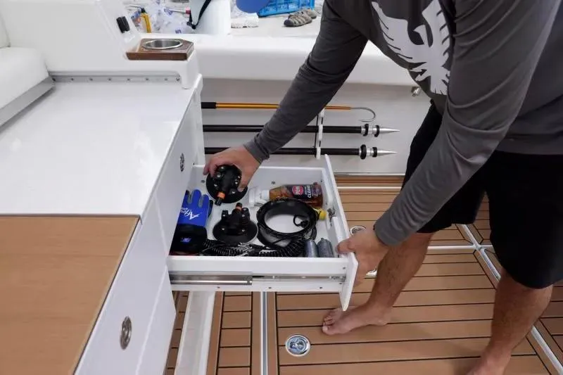 Slide: The Image of 2023 Formula 387 Center Console Fish boat with open storage drawer and fishing gear. - 13