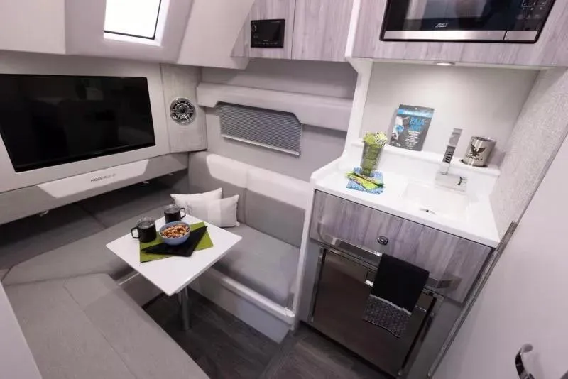 Slide: The Image of 2023 Formula 387 Center Console Fish interior with kitchenette and seating area. - 25