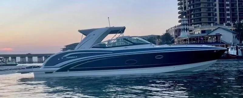 Slide: The Image of 2021 Formula 350 Crossover Bowrider on water at sunset near buildings. - 2