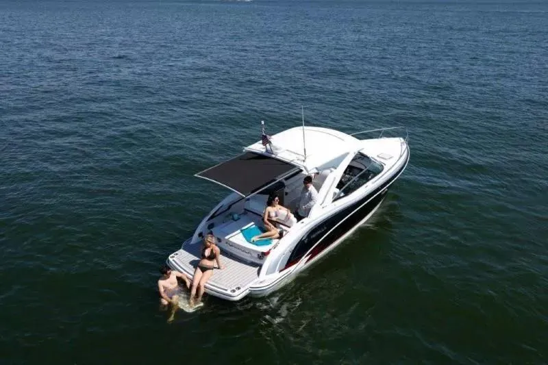 Slide: The Image of 2023 Formula 310 Sun Sport boat with people relaxing on deck in open water. - 8