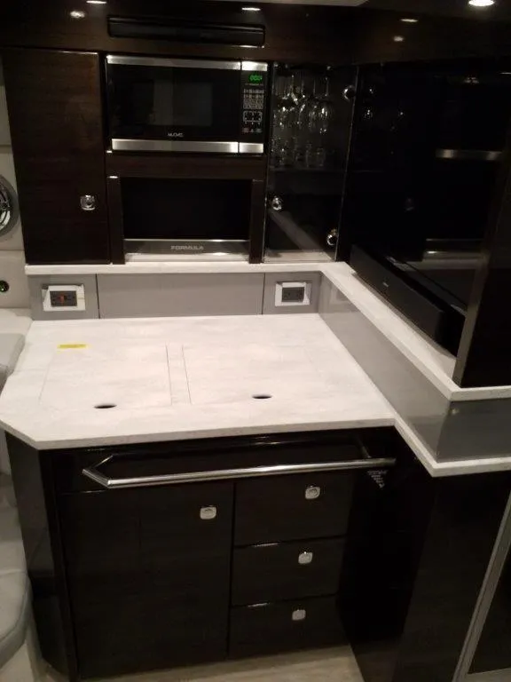 Slide: The Image of 2019 Formula 430 Super Sport Crossover kitchen with modern appliances and sleek cabinetry. - 10