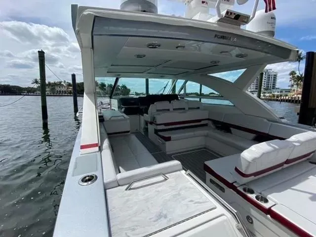 Slide: The Image of 2020 Formula 430 Super Sport Crossover yacht with spacious seating, docked by the water. - 14