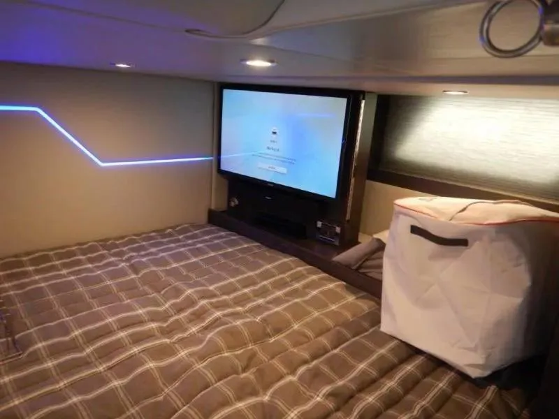 Slide: The Image of Cozy cabin interior of 2020 Formula 430 Super Sport Crossover with TV and plaid bedding. - 22