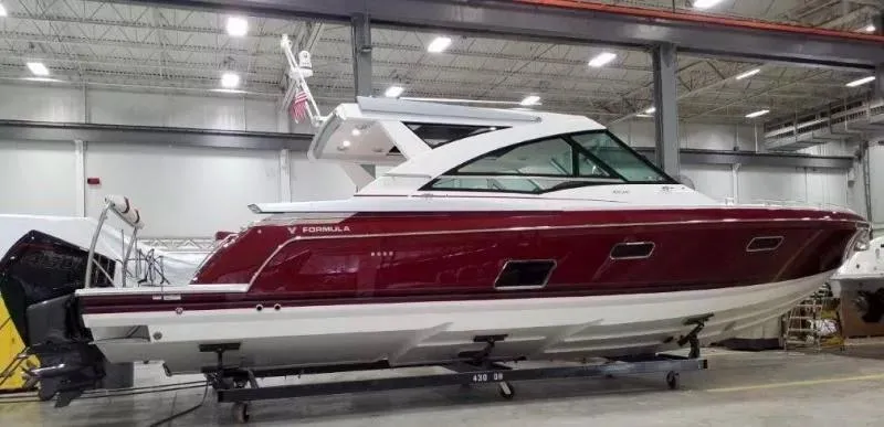 Slide: The Image of 2020 Formula 430 Super Sport Crossover boat in a showroom, featuring sleek red and white design. - 3