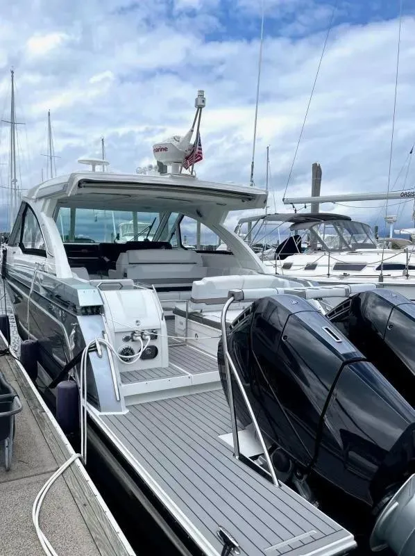 Slide: The Image of 2023 Formula 380 Super Sport Crossover OB docked at marina under cloudy sky. - 2