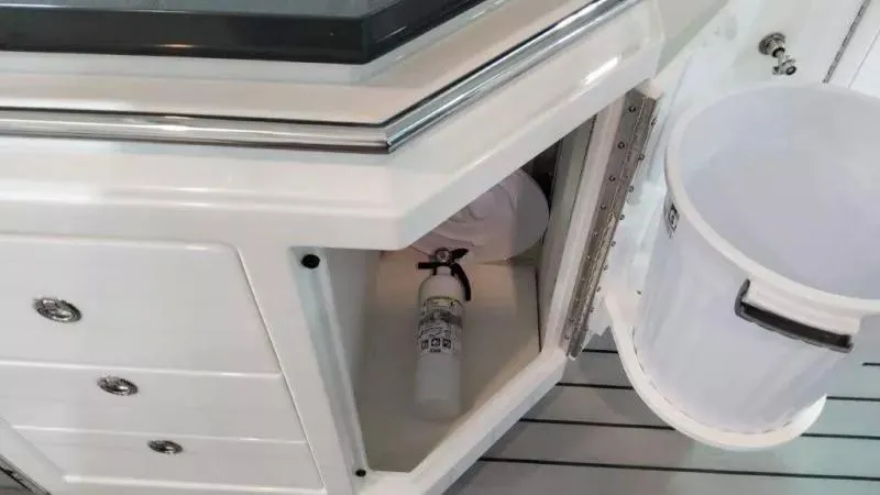 Slide: The Image of 2023 Formula 380 Super Sport Crossover OB interior storage with fire extinguisher and trash bin. - 25