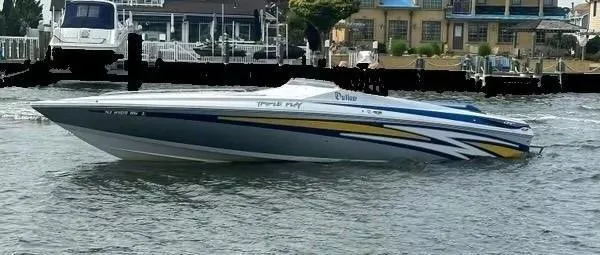 Slide: The Image of 2014 Baja 35 Outlaw speedboat cruising on water near docks and waterfront buildings. - 1