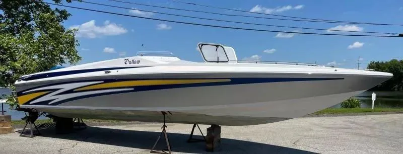 Slide: The Image of 2014 Baja 35 Outlaw boat with vibrant graphics, displayed outdoors on a sunny day. - 2