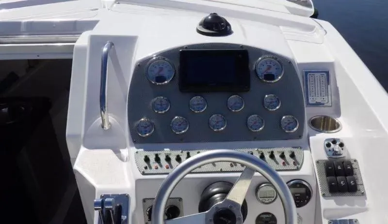 Slide: The Image of 2014 Baja 35 Outlaw boat dashboard with gauges and steering wheel. - 5