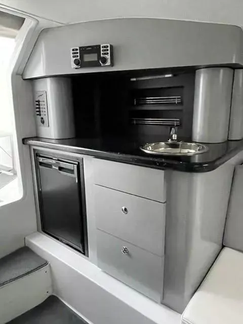 Slide: The Image of 2014 Baja 35 Outlaw interior with kitchenette, featuring sink, fridge, and storage drawers. - 8