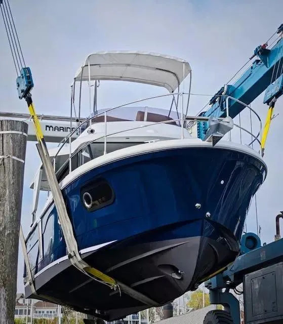 Slide: The Image of 2017 Beneteau Swift Trawler 30 being lifted by a crane at a marina. - 1