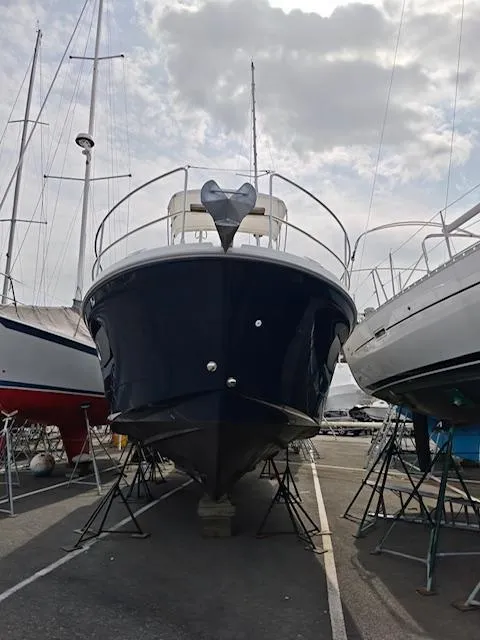 Slide: The Image of 2017 Beneteau Swift Trawler 30 on stands, viewed from the front in a marina. - 17