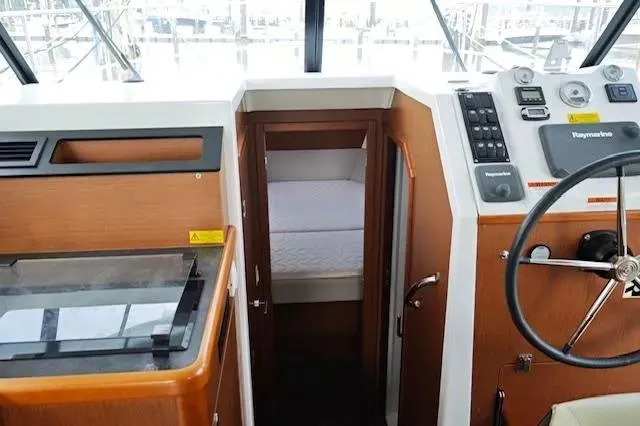 Slide: The Image of 2017 Beneteau Swift Trawler 30 helm with wood finish and cabin view. - 25