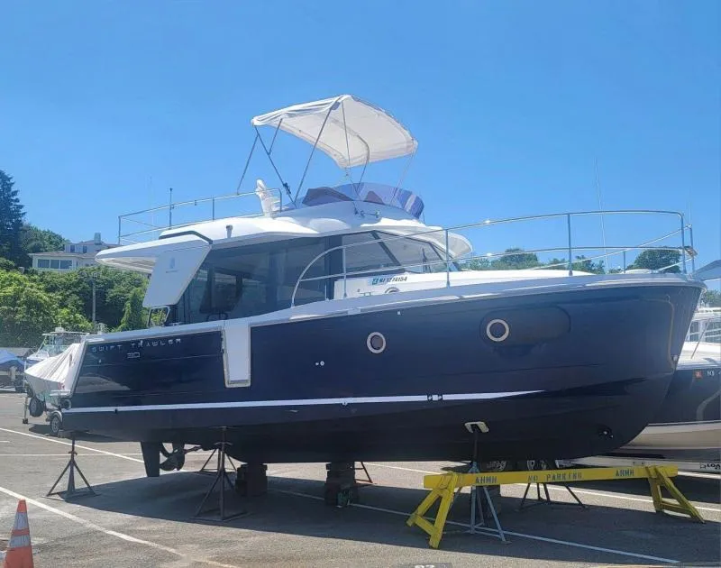 Slide: The Image of 2017 Beneteau Swift Trawler 30 on display in a marina setting. - 3