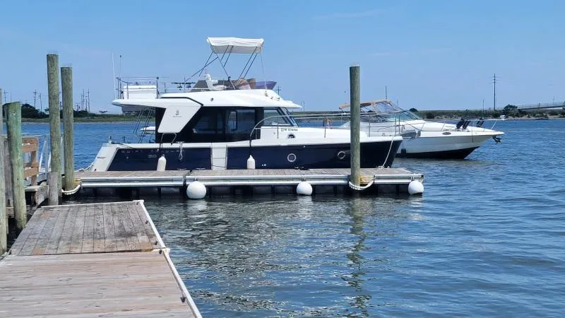 Slide: The Image of 2017 Beneteau Swift Trawler 30 docked on calm water under clear blue sky. - 4