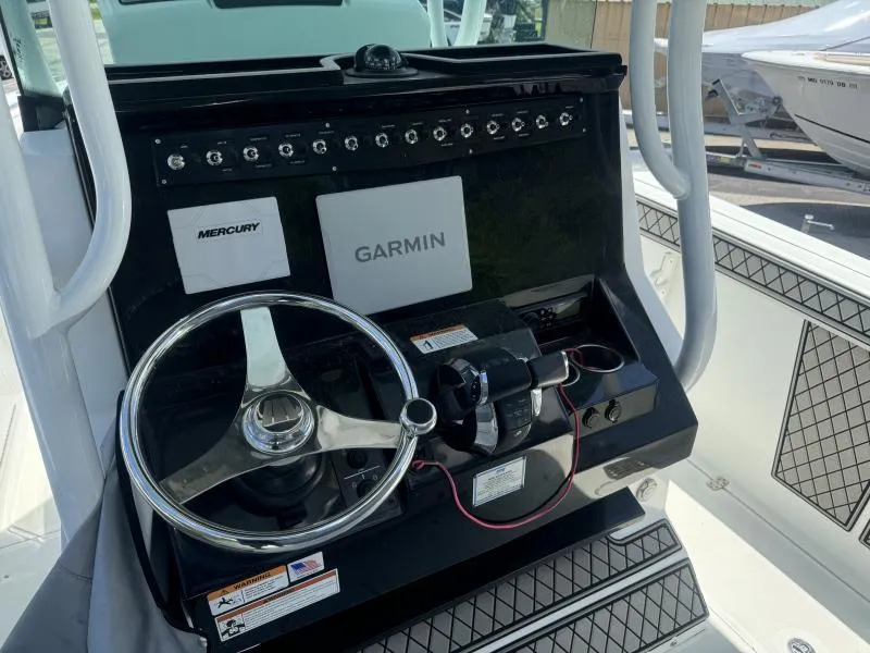 Slide: The Image of 2022 Wellcraft 262 Fisherman boat dashboard with Garmin and Mercury controls. - 22