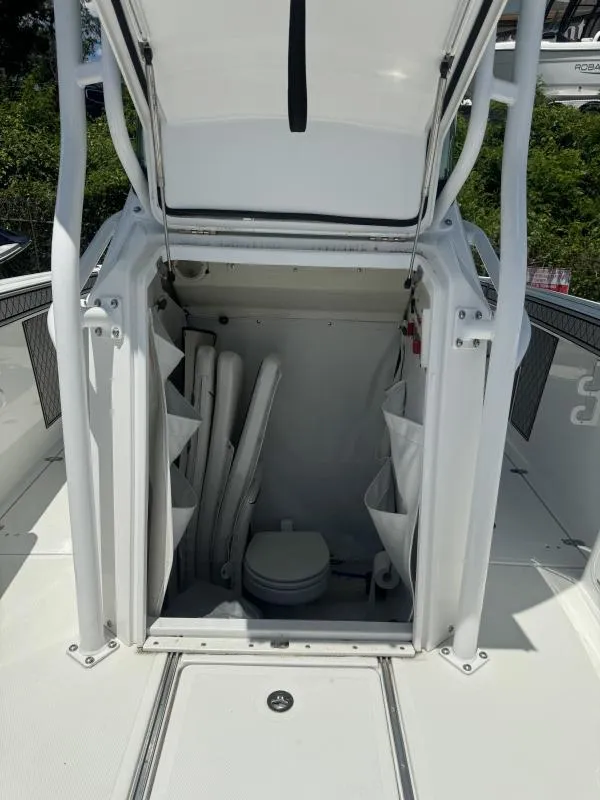Slide: The Image of 2022 Wellcraft 262 Fisherman boat storage compartment with open hatch and visible toilet. - 23