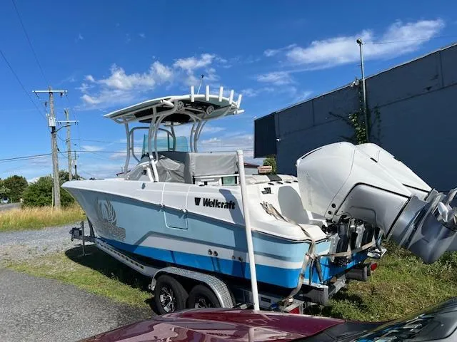 Slide: The Image of 2022 Wellcraft 262 Fisherman boat on trailer, parked outdoors under clear blue sky. - 3