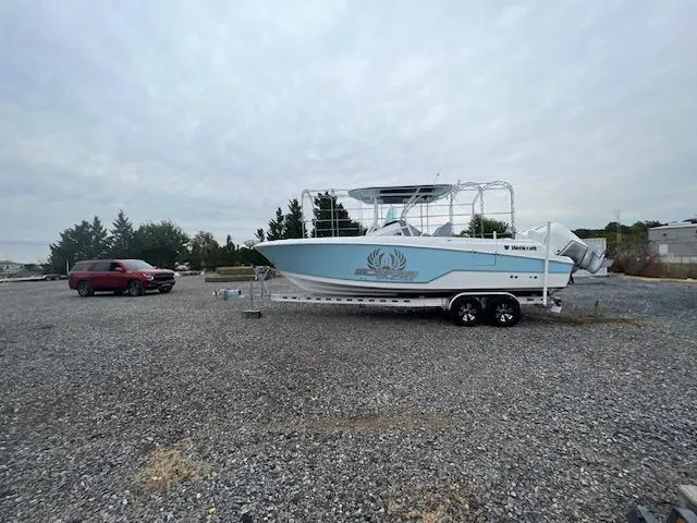 Slide: The Image of 2022 Wellcraft 262 Fisherman boat on trailer in gravel lot, overcast sky. - 6