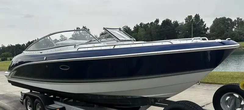Slide: The Image of 2013 Formula 270 Bowrider boat on trailer, sleek design, parked near water. - 3