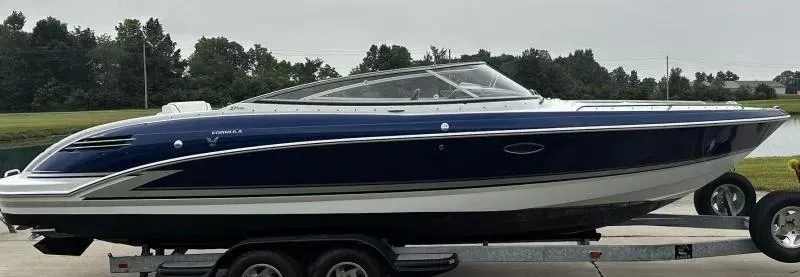 Slide: The Image of 2013 Formula 270 Bowrider boat on trailer, sleek design, blue and white exterior. - 5