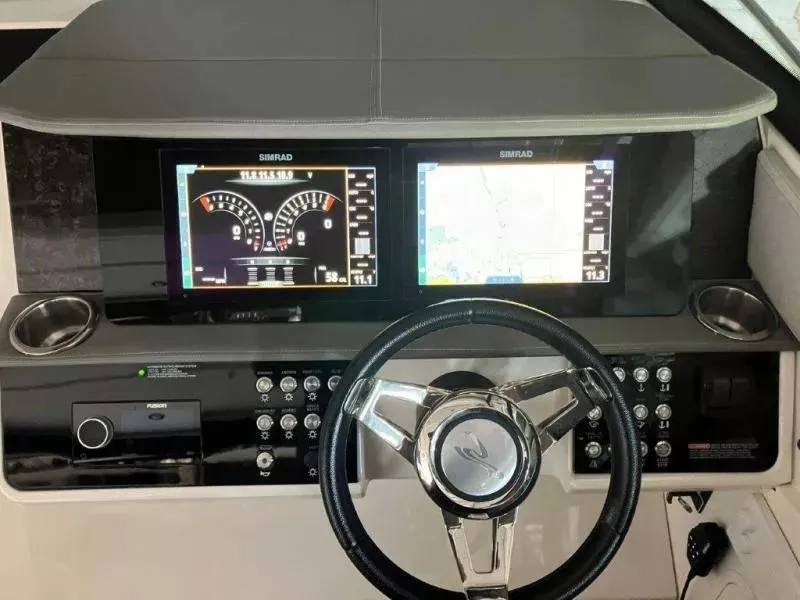 Slide: The Image of 2020 Sea Ray Sundancer 320 OB dashboard with dual Simrad displays and modern controls. - 12
