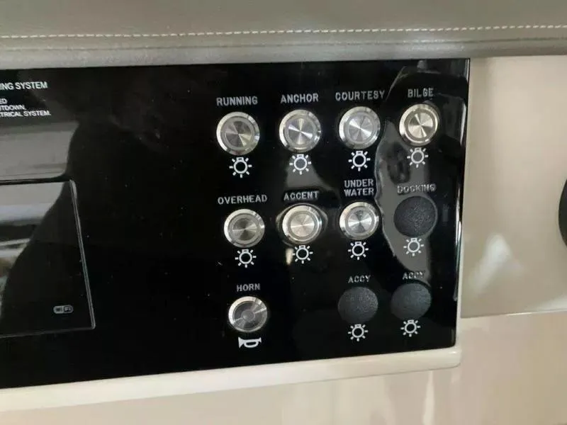 Slide: The Image of Control panel of a 2020 Sea Ray Sundancer 320 OB boat with various switches. - 14