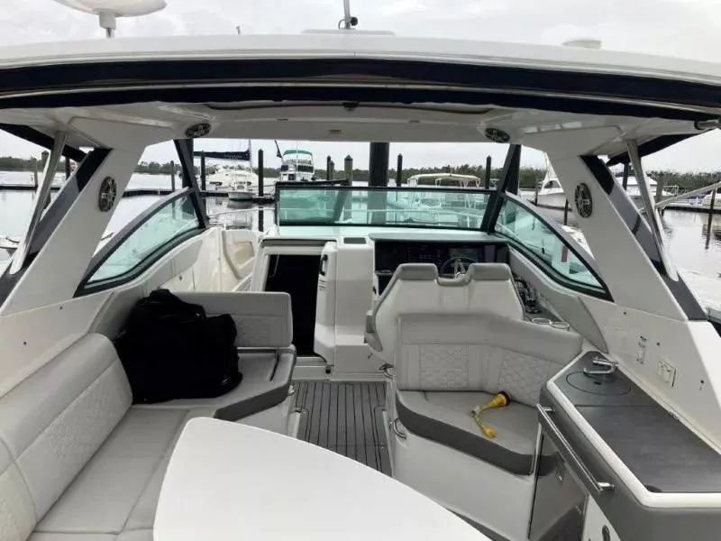 Slide: The Image of 2020 Sea Ray Sundancer 320 OB interior with seating and helm, docked at marina. - 24