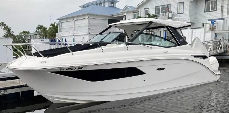 Slide: The Image of 2020 Sea Ray Sundancer 320 OB docked at marina, sleek white design. - 3