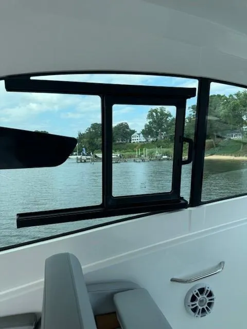 Slide: The Image of 2024 Beneteau Gran Turismo 32 interior view with open window overlooking serene waterfront. - 18