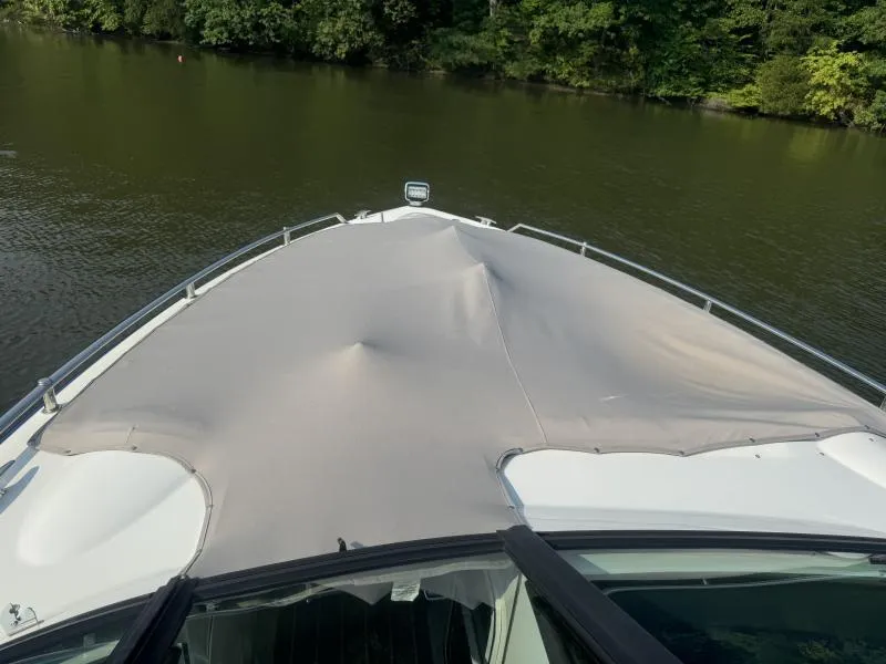 Slide: The Image of 2020 Formula Boats 350 Crossover Bowrider with covered bow on a calm lake. - 17