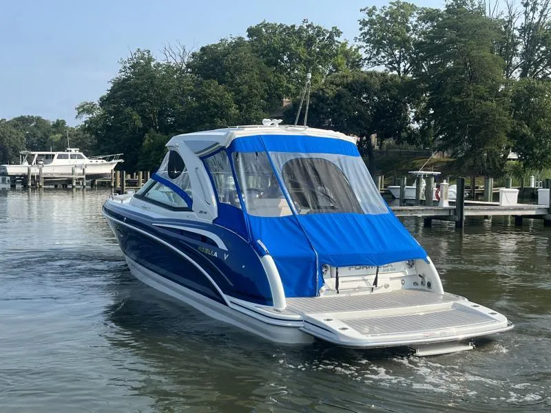 Slide: The Image of 2020 Formula Boats 350 Crossover Bowrider on calm water near a dock. - 6