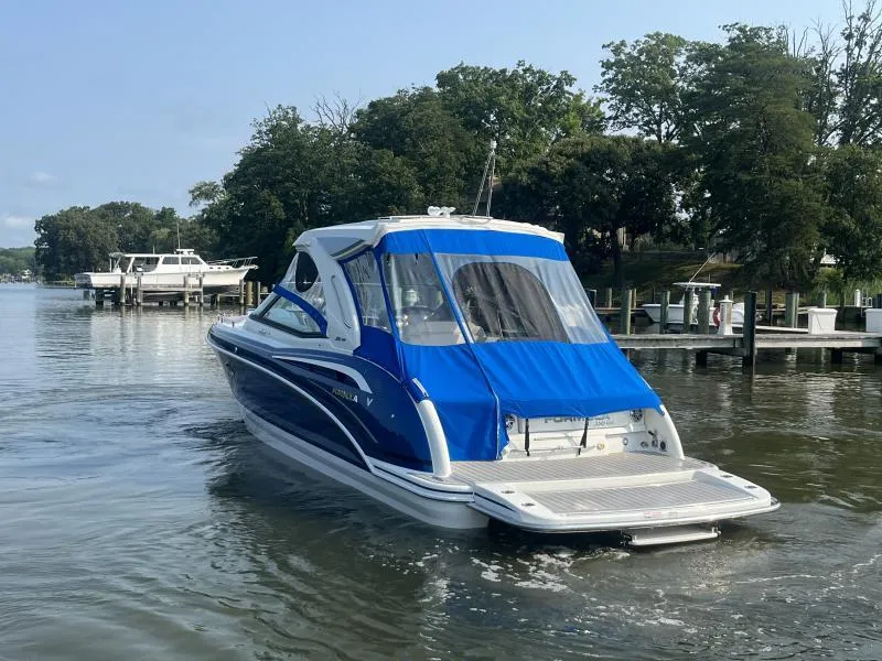 Slide: The Image of 2020 Formula Boats 350 Crossover Bowrider on calm water near a dock. - 7