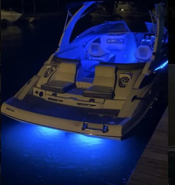 Slide: The Image of 2022 Crownline 265 SS boat with blue LED lights at night. - 10