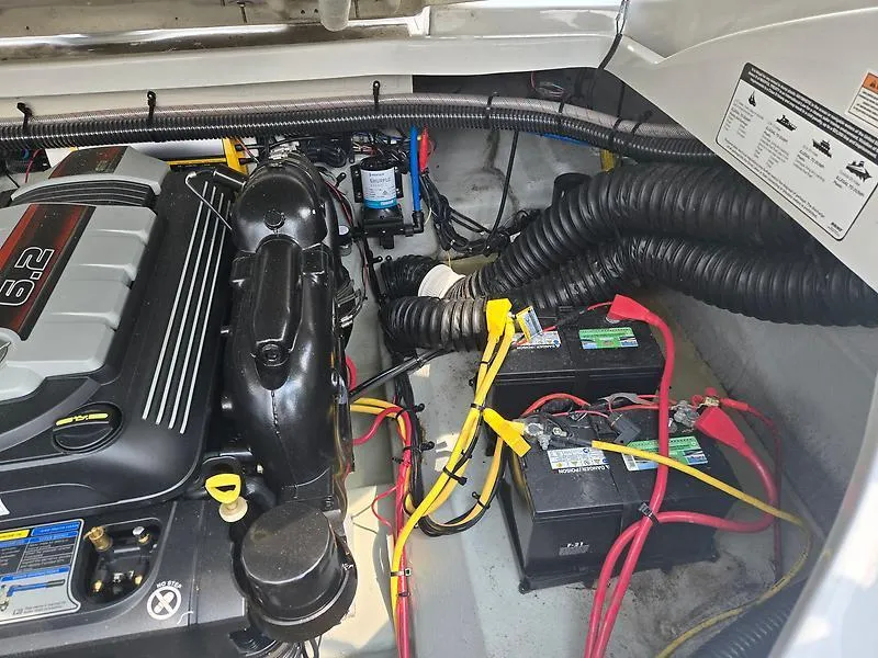 Slide: The Image of Engine compartment of a 2022 Crownline 265 SS boat, featuring batteries and wiring. - 12