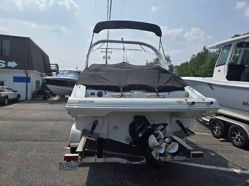 Slide: The Image of 2022 Crownline 265 SS boat with cover, parked on a trailer in a marina. - 6