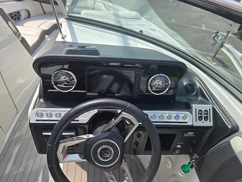 Slide: The Image of 2022 Crownline 265 SS boat dashboard with steering wheel and control panel. - 8