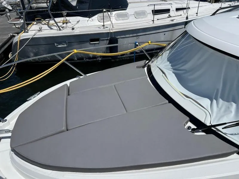 Slide: The Image of 2023 Beneteau Antares 8 boat with cushioned deck, docked beside another vessel. - 10