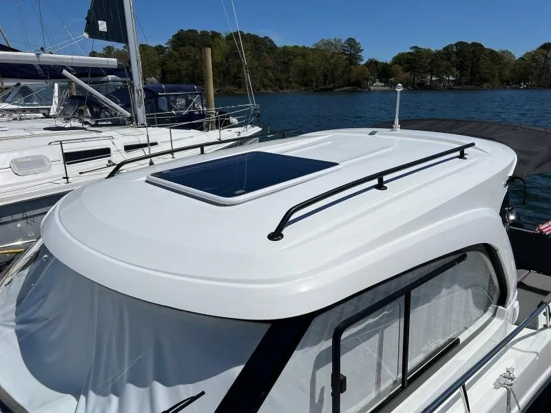 Slide: The Image of 2023 Beneteau Antares 8 boat with sunroof, docked on a sunny day. - 12