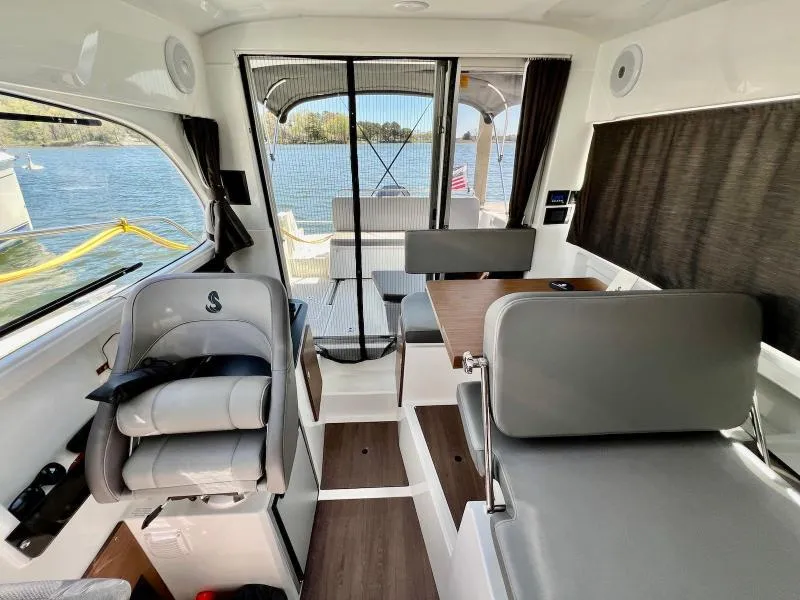 Slide: The Image of Interior of 2023 Beneteau Antares 8 boat, featuring seating and a view of the water. - 18